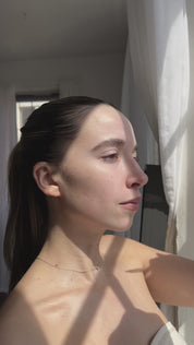 Girl putting rose oil on face