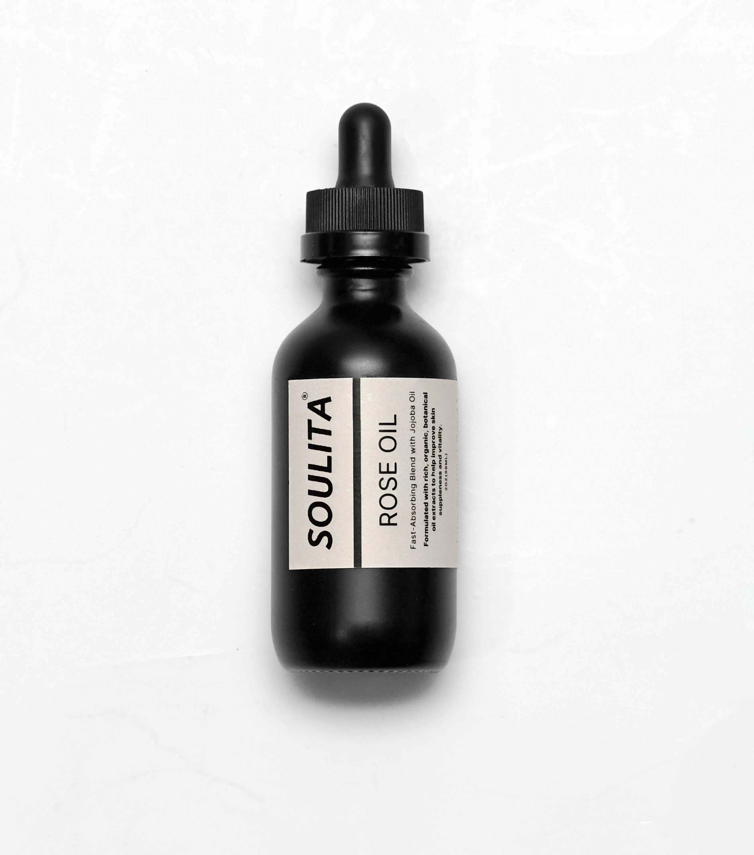 Bottle of Soulita's natural rose oil surrounded by promoting hydration and glowing skin