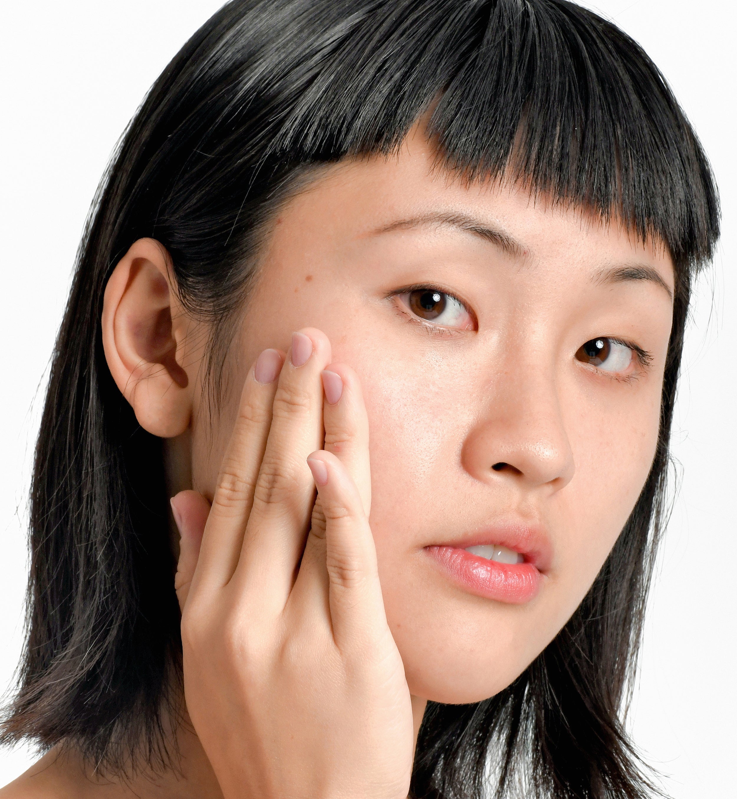 Asian Natural Skincare Model Holding her hand to her face 