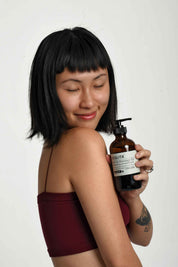 asian short hair model holding our bath and massage body oil for natural body care